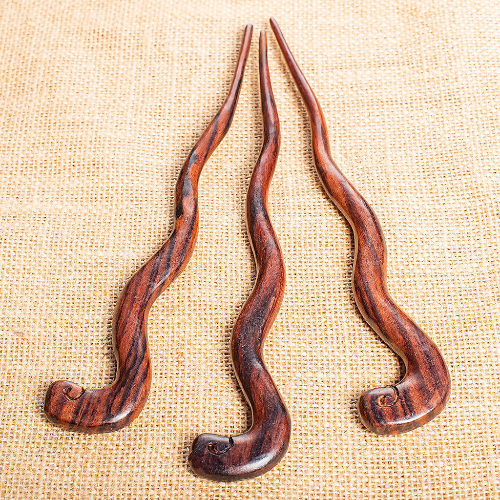 wooden hair stick naively carved to resemble a curly snake