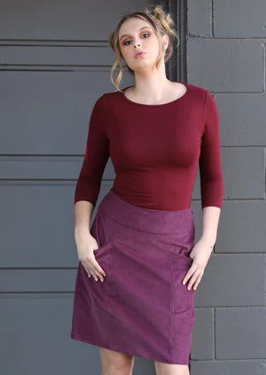 Model wearing a karma east cord skirt on a grey background