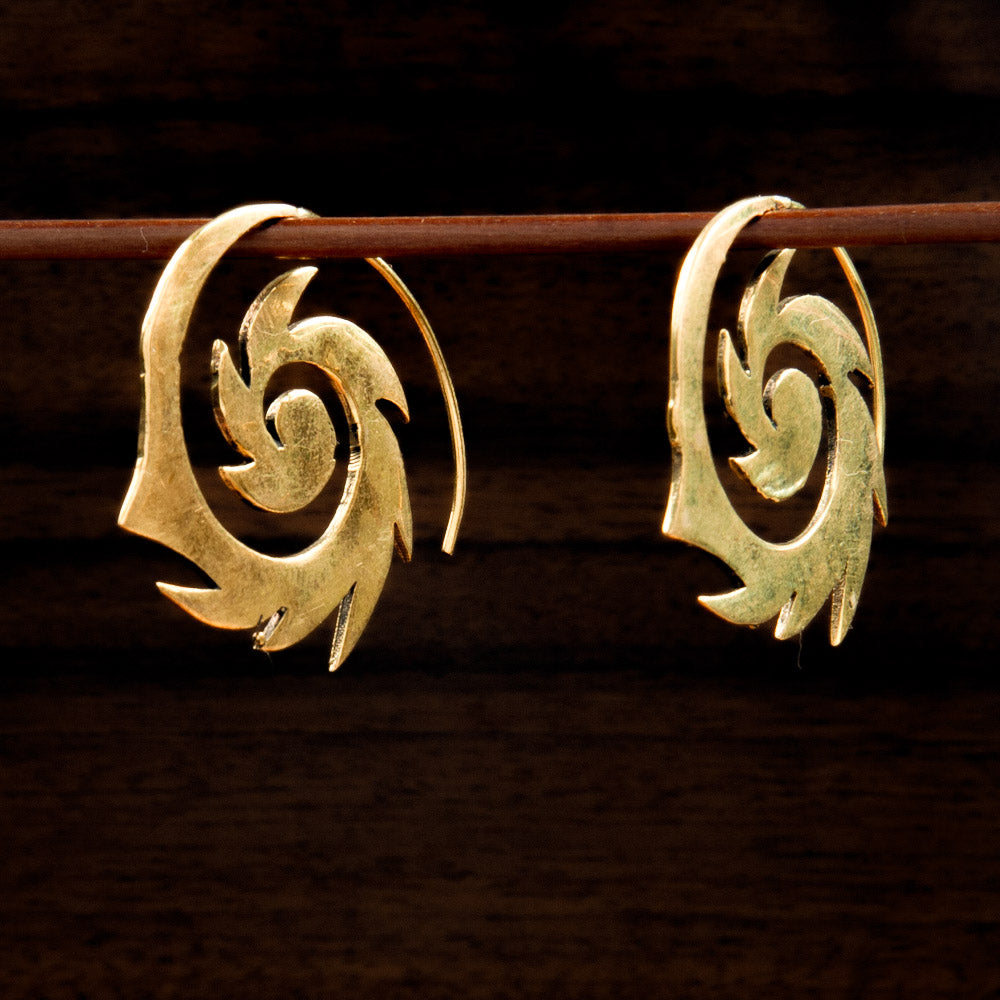 Two Brass earrings featuring a spiral design on a dark background