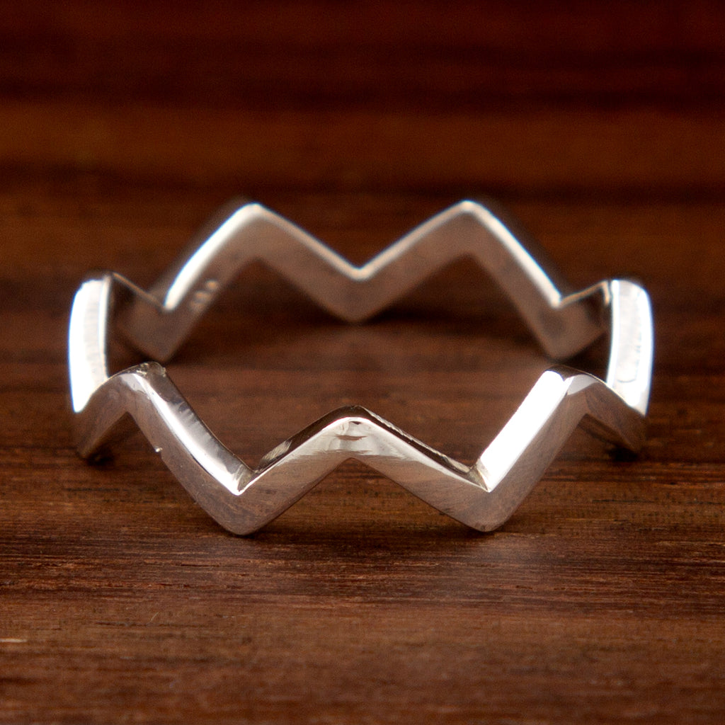 A sterling silver ring featuring a zig zag shape on a wooden background