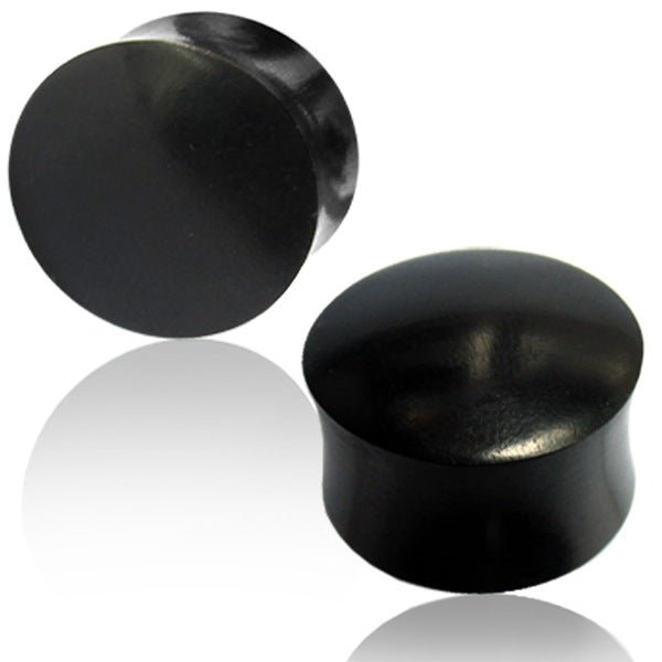 Two black plugs made of arang wood on a white background