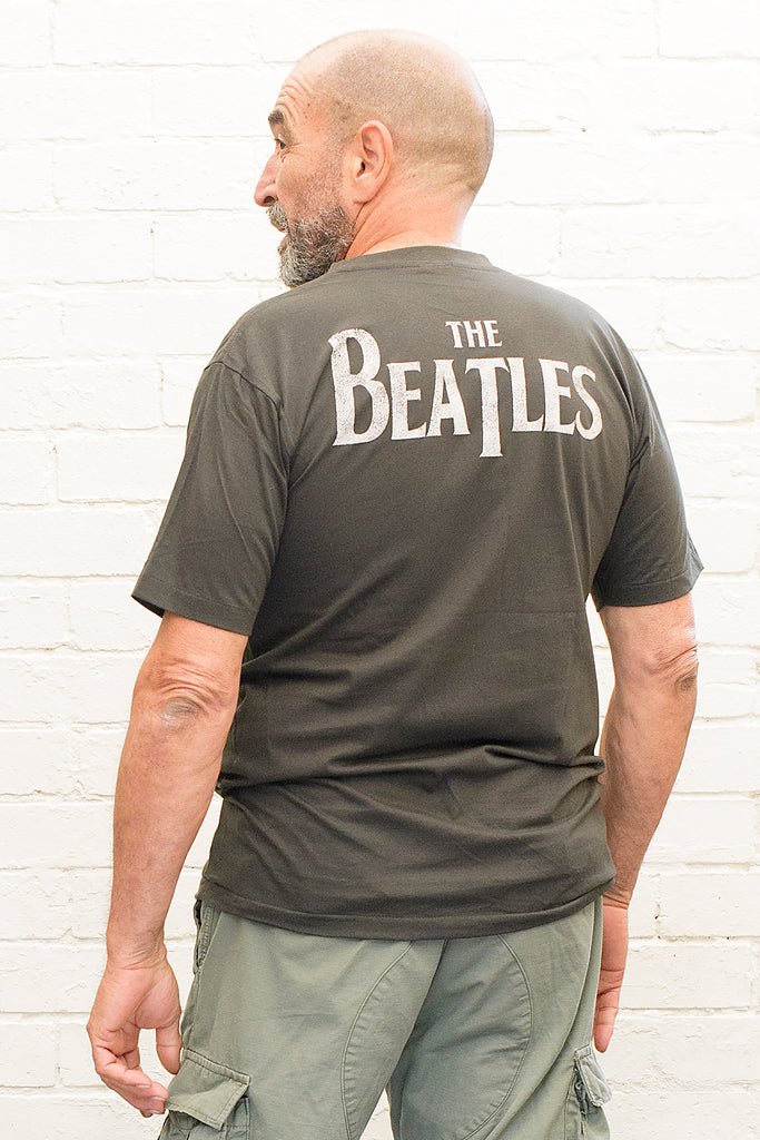 model wearing black cotton t-shirt with the beatles logo and band member portraits print on front