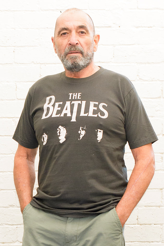 model wearing black cotton t-shirt with the beatles logo and band member portraits print on front