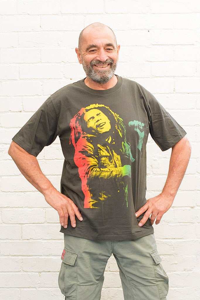 model wearing black cotton t-shirt with a red gold and green toned photographic print of bob marley singing on front