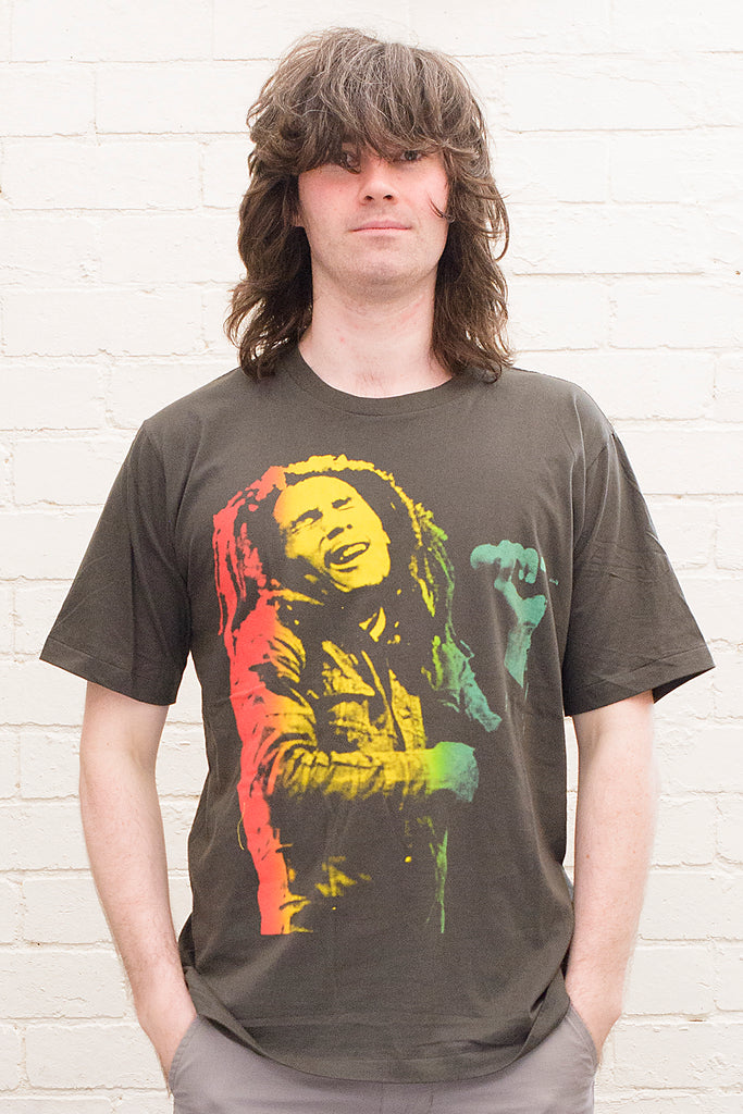 model wearing black cotton t-shirt with a red gold and green toned photographic print of bob marley singing on front