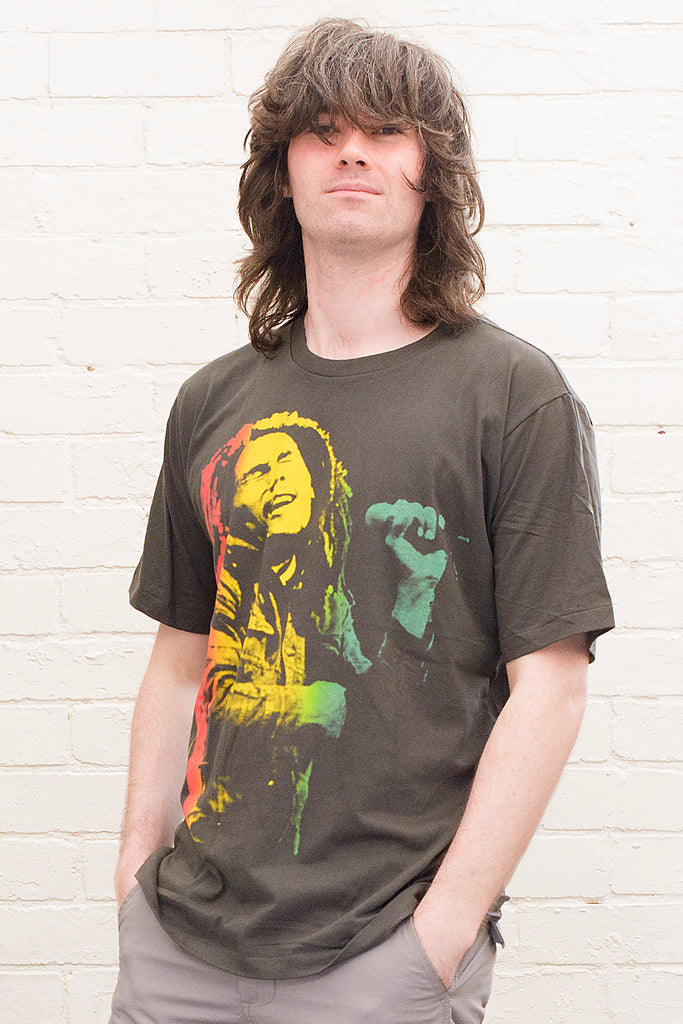 model wearing black cotton t-shirt with a red gold and green toned photographic print of bob marley singing on front