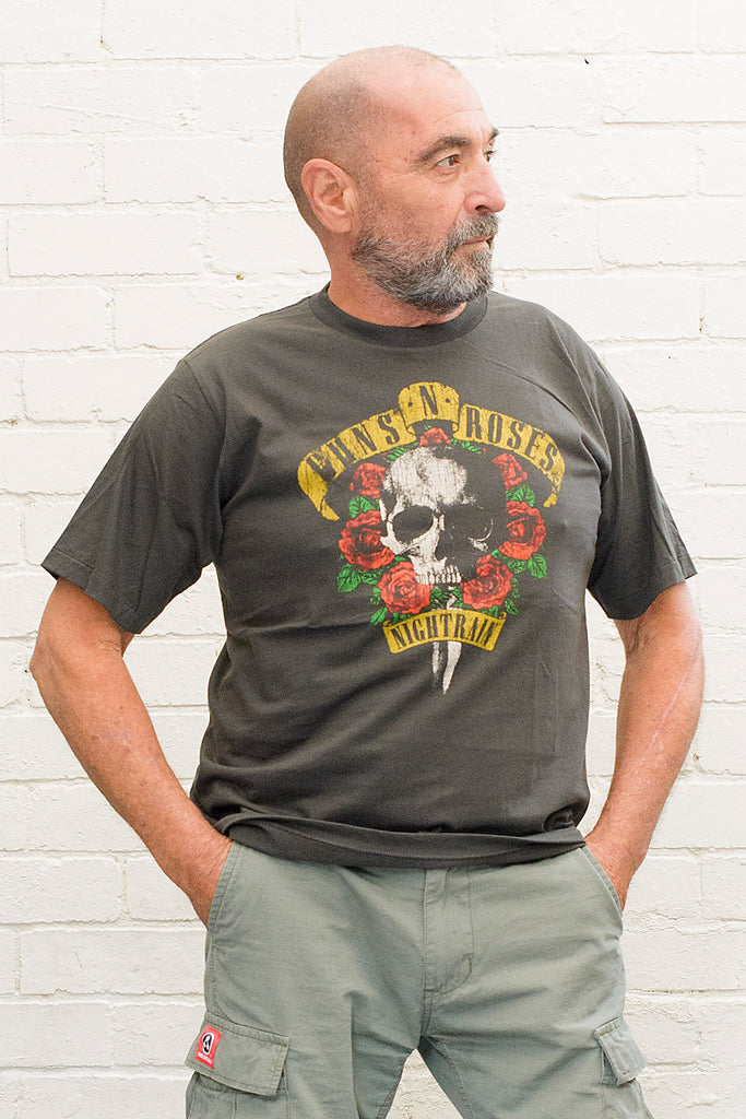 model wearing black cotton t-shirt with guns 'n' roses nightrain skull and roses graphic print on front