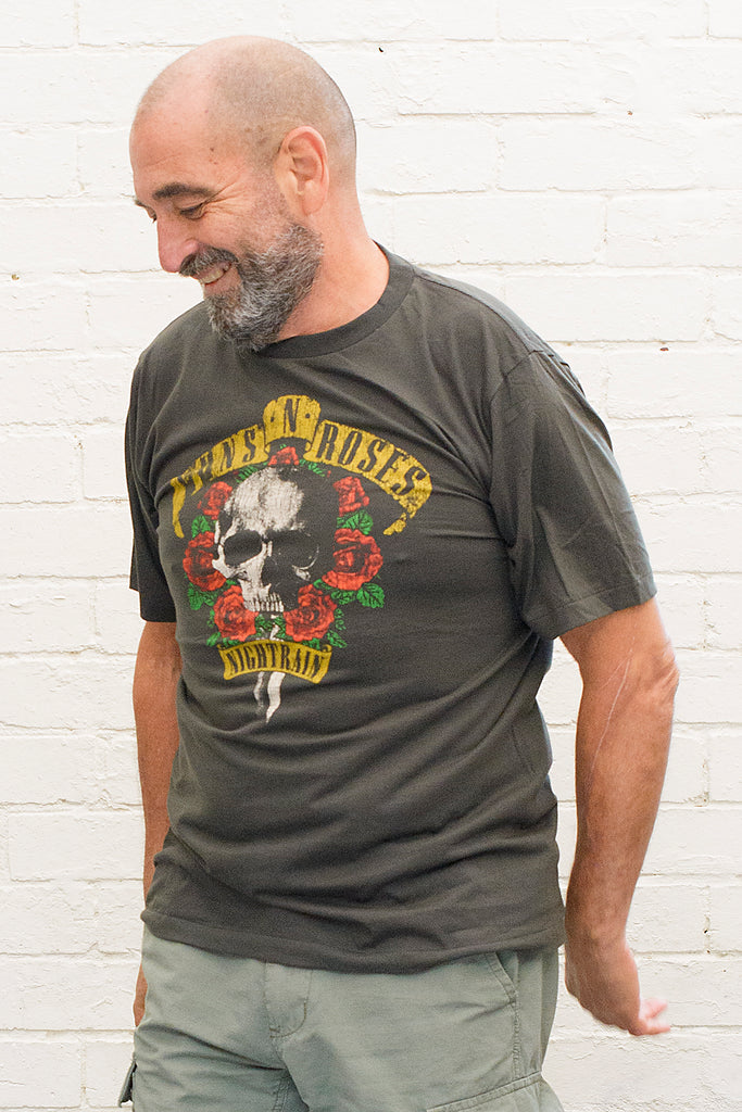 model wearing black cotton t-shirt with guns 'n' roses nightrain skull and roses graphic print on front