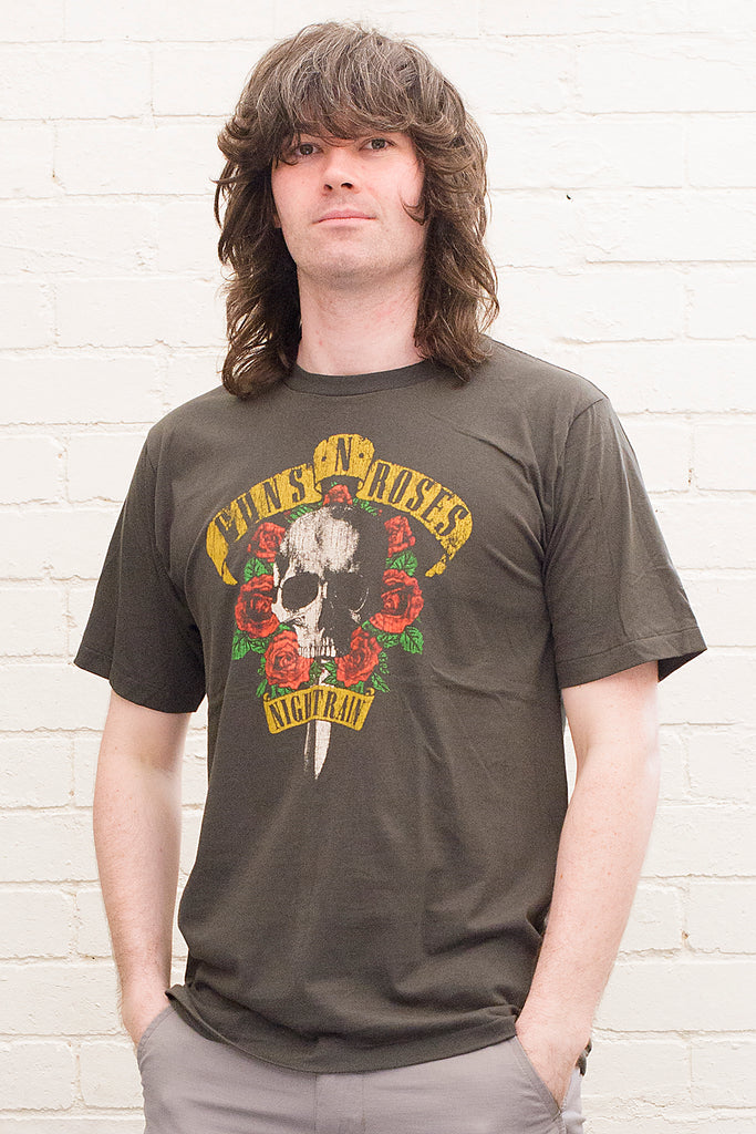 model wearing black cotton t-shirt with guns 'n' roses nightrain skull and roses graphic print on front