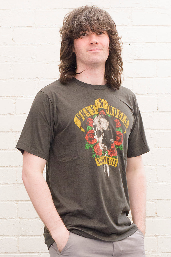 model wearing black cotton t-shirt with guns 'n' roses nightrain skull and roses graphic print on front