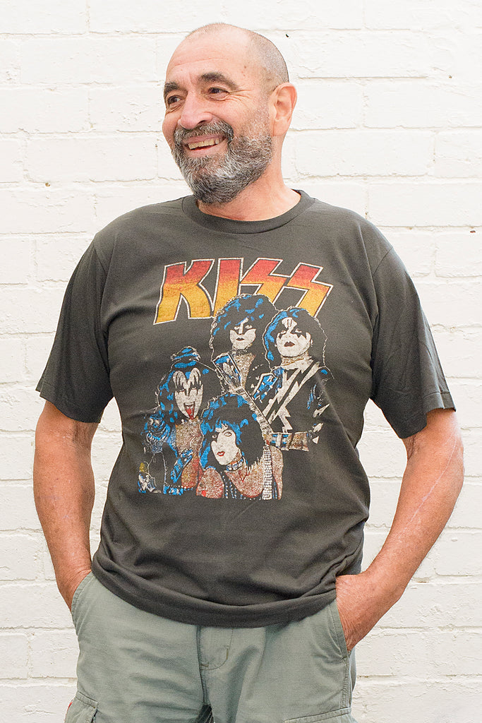 model wearing black cotton t-shirt with kiss logo and image of band members printed on front