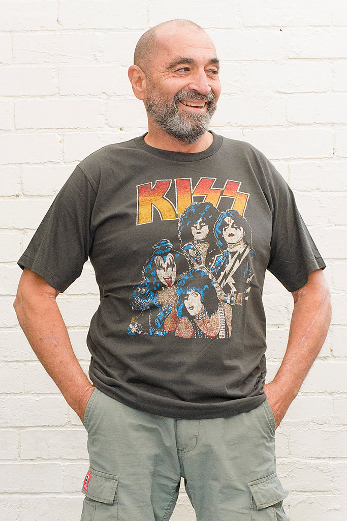 model wearing black cotton t-shirt with kiss logo and image of band members printed on front