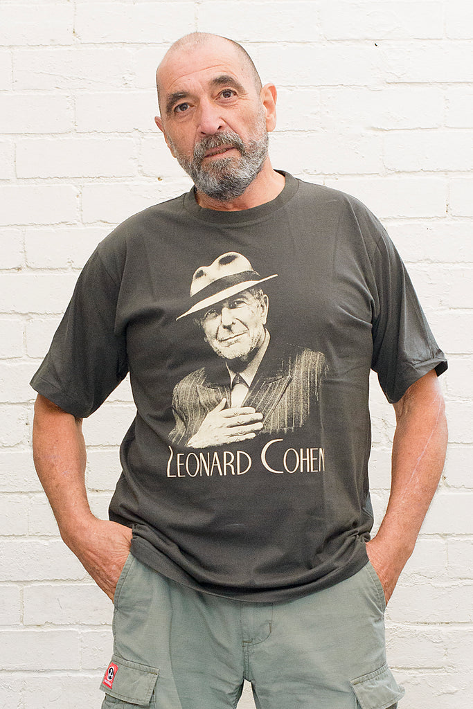 model wearing black cotton t-shirt with image of leonard cohen wearing hat and pinstripe suit with leonard cohen text printed below on front