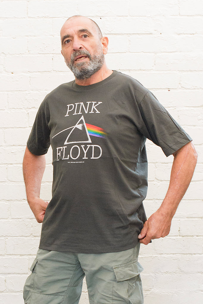 model wearing black cotton t-shirt with Pink Floyd Text and dark side of the moon refracting prism album cover artwork printed on front