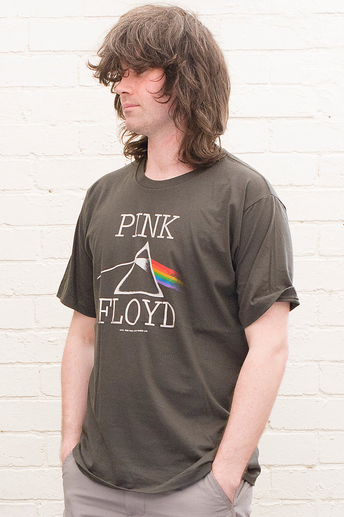 model wearing black cotton t-shirt with Pink Floyd Text and dark side of the moon refracting prism album cover artwork printed on front