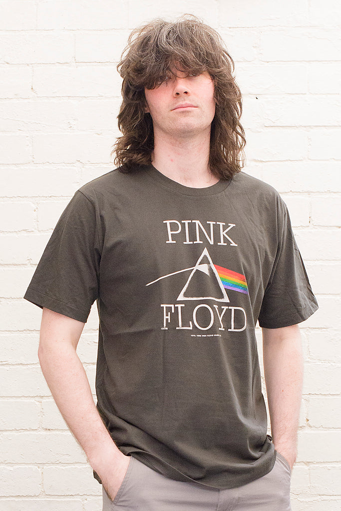 model wearing black cotton t-shirt with Pink Floyd Text and dark side of the moon refracting prism album cover artwork printed on front