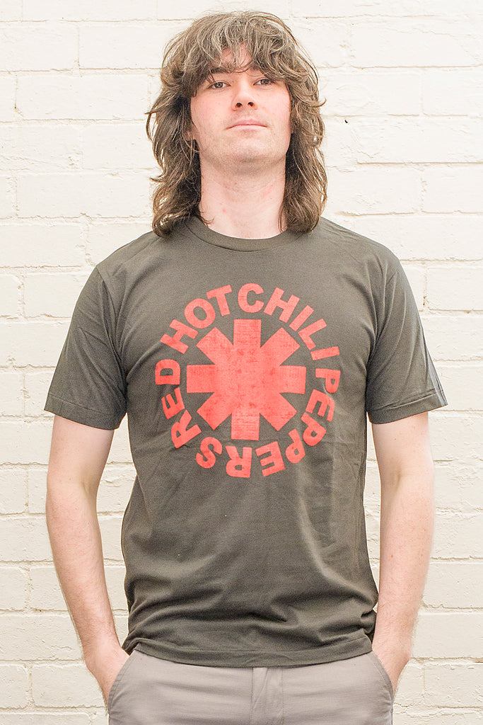 model wearing black cotton t-shirt with red hot chili peppers logo and band name printed on front