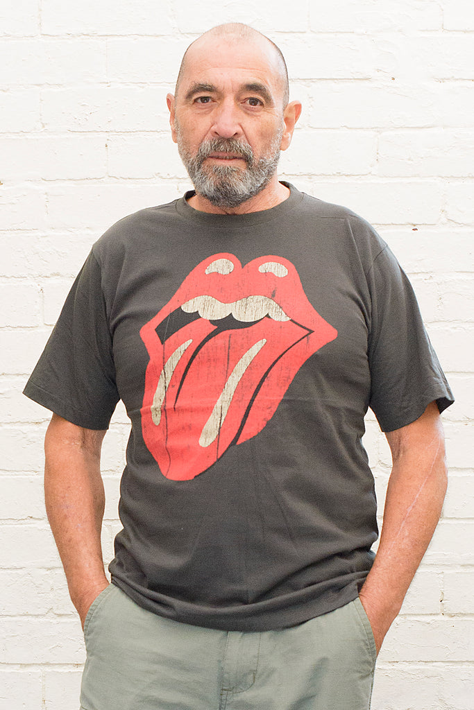 model wearing black cotton t-shirt with rolling stones tongue and lips logo printed on front