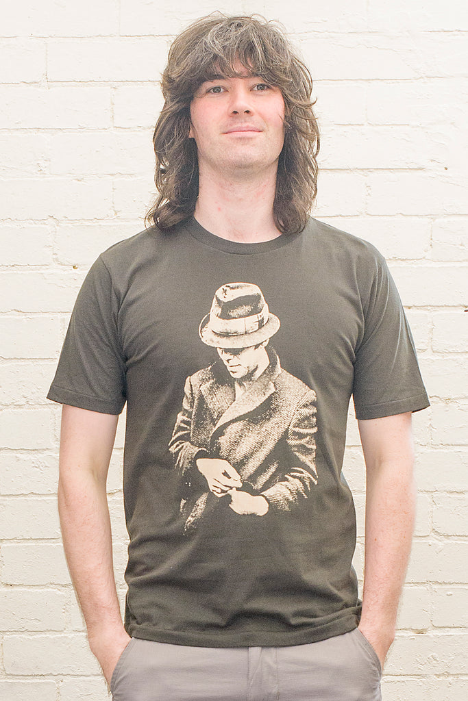 model wearing black t-shirt featuring a print of tom waits wearing a hat and overcoat on the front