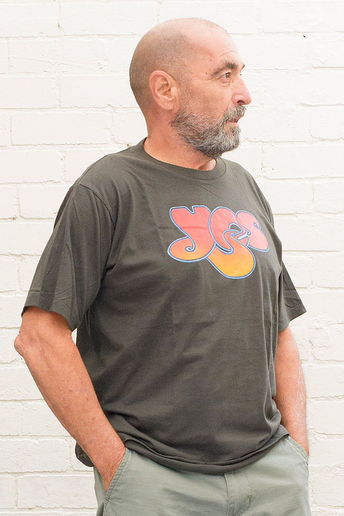 model wearing black t-shirt with the yes band logo printed on the front