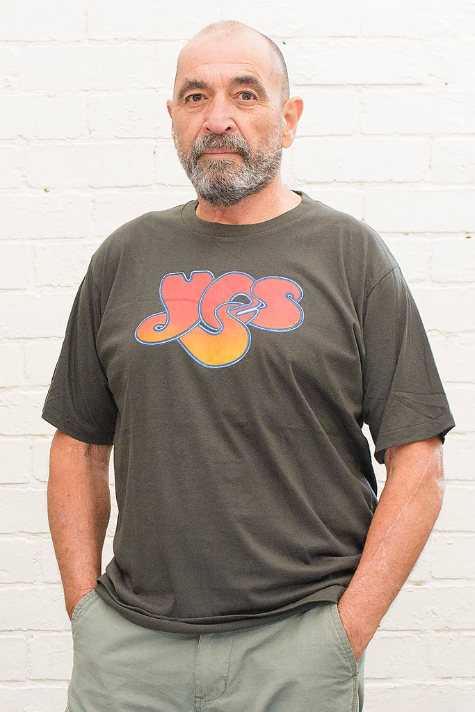 model wearing black t-shirt with the yes band logo printed on the front