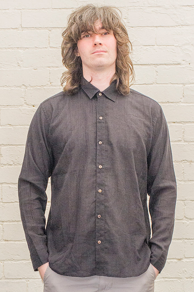 model wearing blackcotton button up long sleeved collared shirt from the front