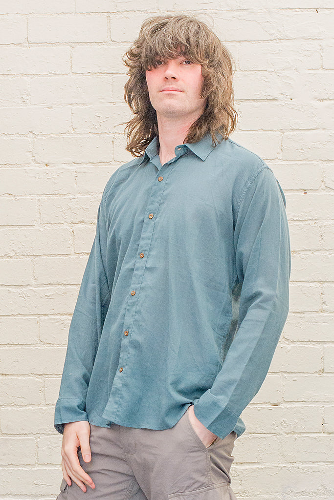 model wearing teal cotton button up long sleeved collared shirt from the front