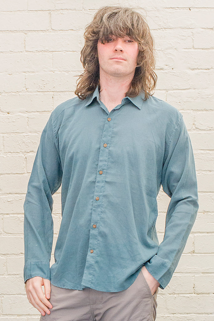 model wearing teal cotton button up long sleeved collared shirt from the front