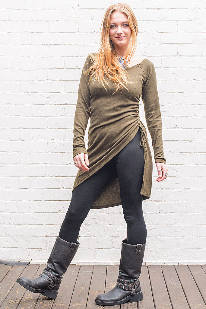 Model wearing a Khione knee length knit dress with boat collar and adjustable asymmetric hemline in army green