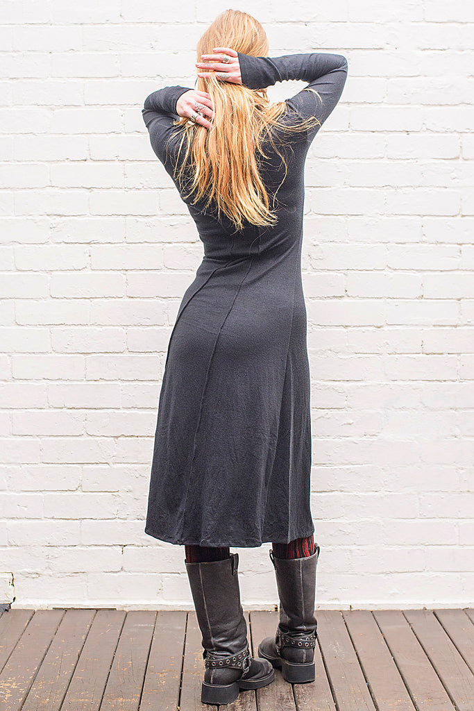 Model wearing a Marzanna midi length knit dress in black from back