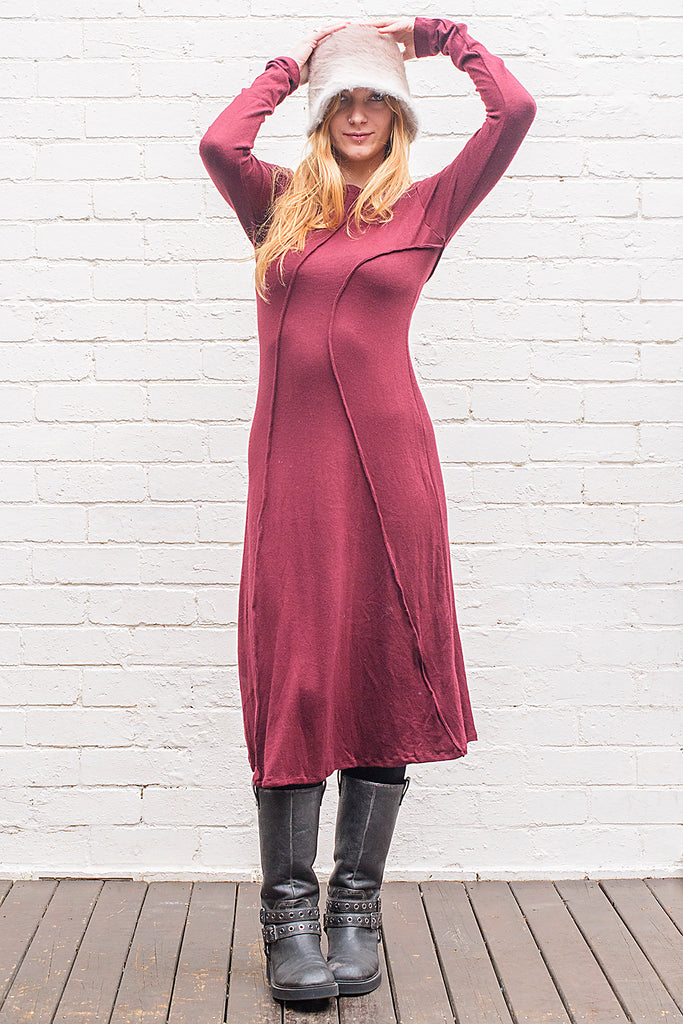 Model wearing a Marzanna midi length knit dress in maroon and wearing a felt hat