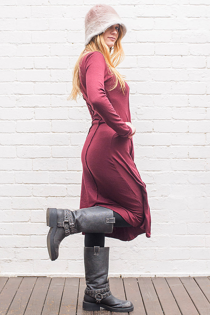 Model wearing a Marzanna midi length knit dress in maroon from side