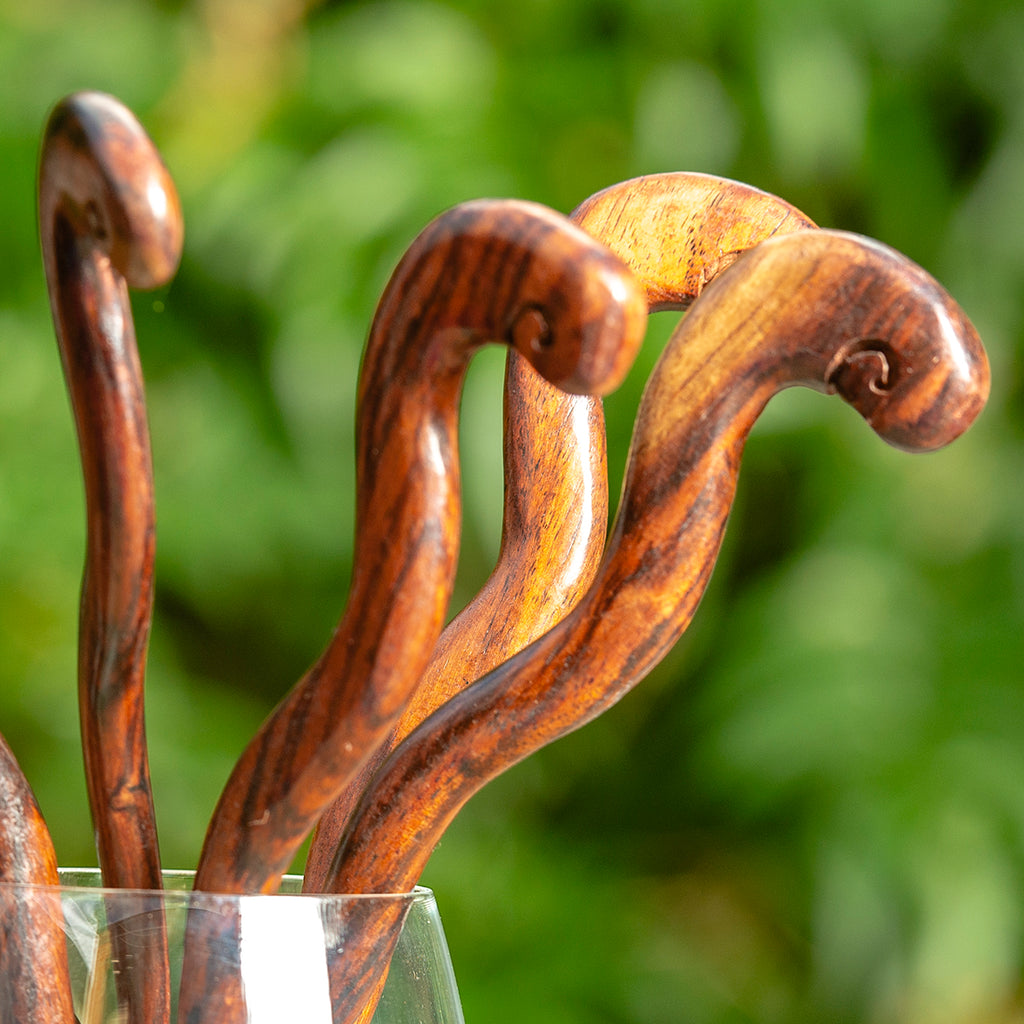 wooden hair stick naively carved to resemble a curly snake detail