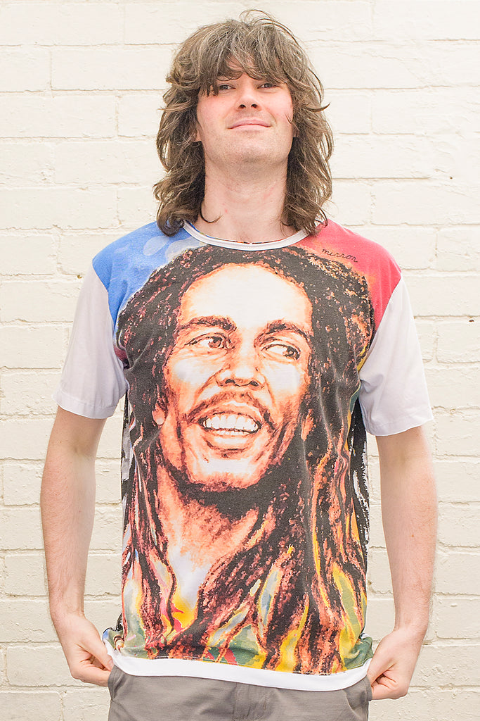 model wearing a white T-shirt with a colourful image of Bob Marley printed on the front