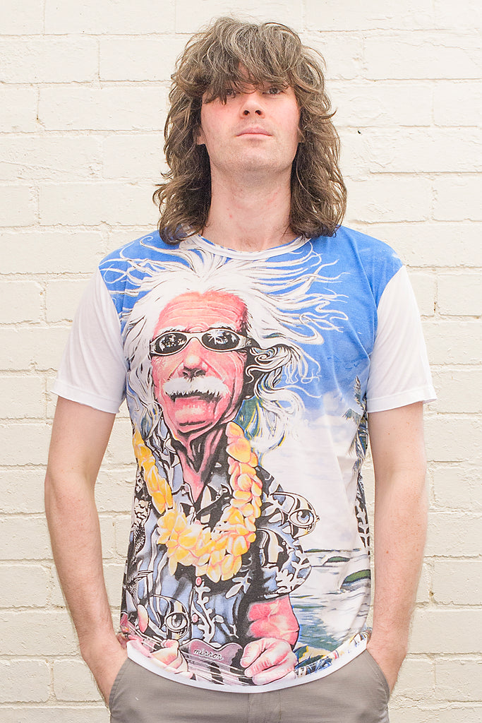 model wearing a white T-shirt featuring a colourful caricature of albert einstein wearing sunglasses a hawaiian shirt and flower lei whilst playing ukelele at the beach printed on the front