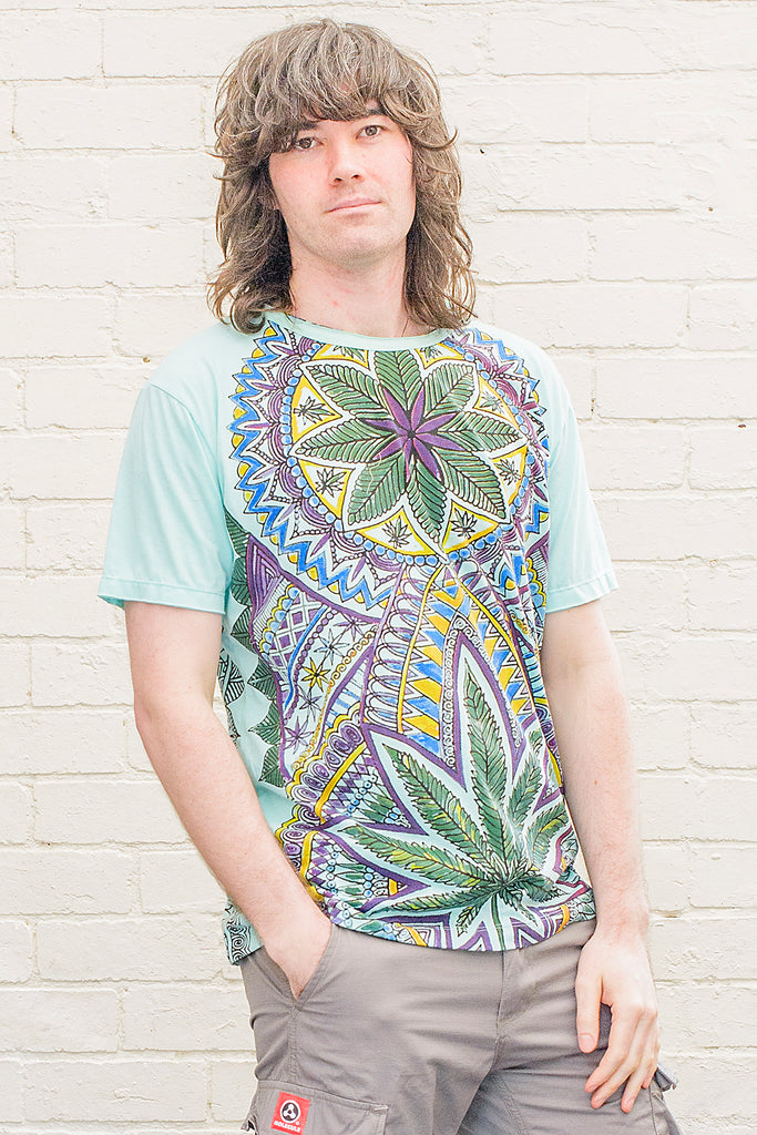 model wearing a light blue t-shirt printed with a colourful marijuana leaf themed mandala style artwork on the front