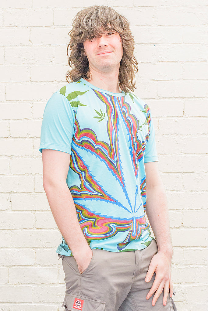 model wearing a bright blue t-shirt printed with a colourful psychedelic marijuana leaf graphic design on the front