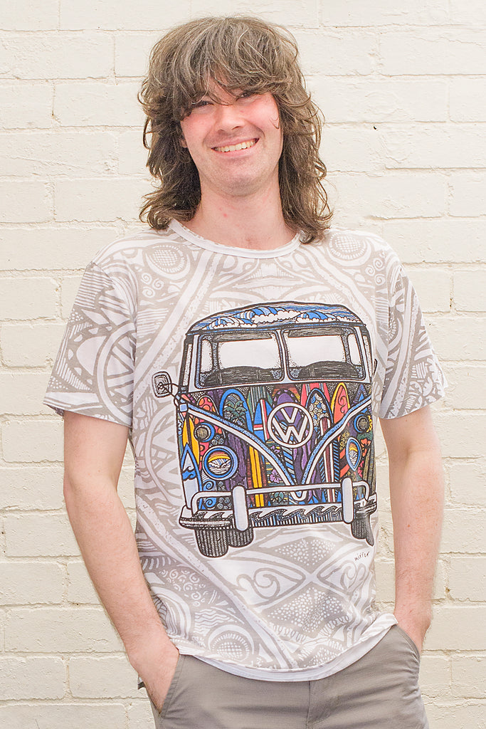 model wearing a white t-shirt printed with a colourful 1970s style doodle artwork of a split screen volkswagen kombi van with surf themed paintwork on a psychedelic monochrome background from the front