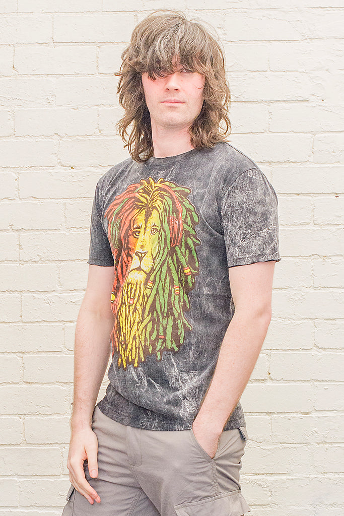 model wearing a black stonewash t-shirt printed with a lion of judah with red gold and green dreadlocks cartoon graphic on the front