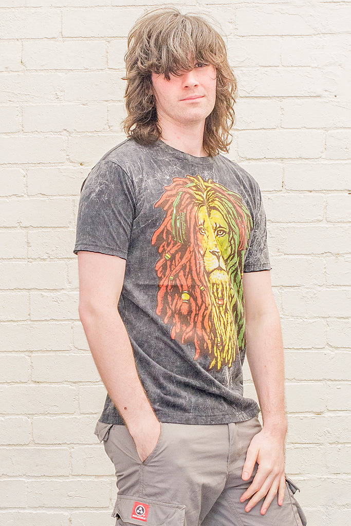 model wearing a black stonewash t-shirt printed with a lion of judah with red gold and green dreadlocks cartoon graphic on the front