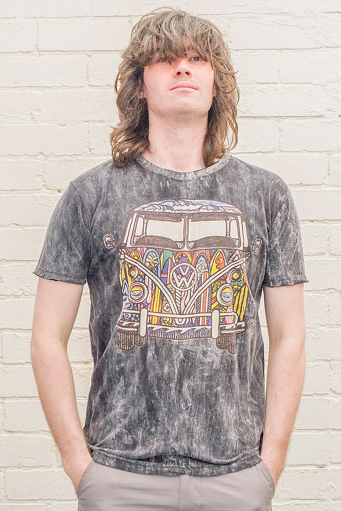 model wearing a black stonewash t-shirt printed with a colourful 1970s style doodle artwork of a split screen volkswagen kombi van with surf themed paintwork from the front