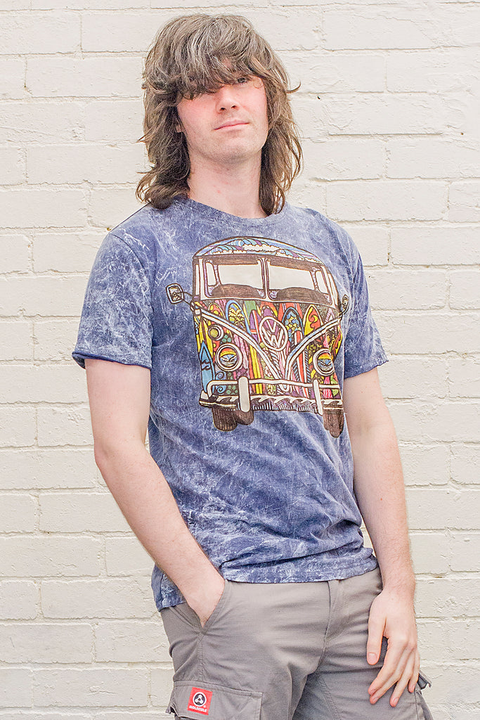 model wearing a dark blue stonewash t-shirt printed with a colourful 1970s style doodle artwork of a split screen volkswagen kombi van with surf themed paintwork from the front