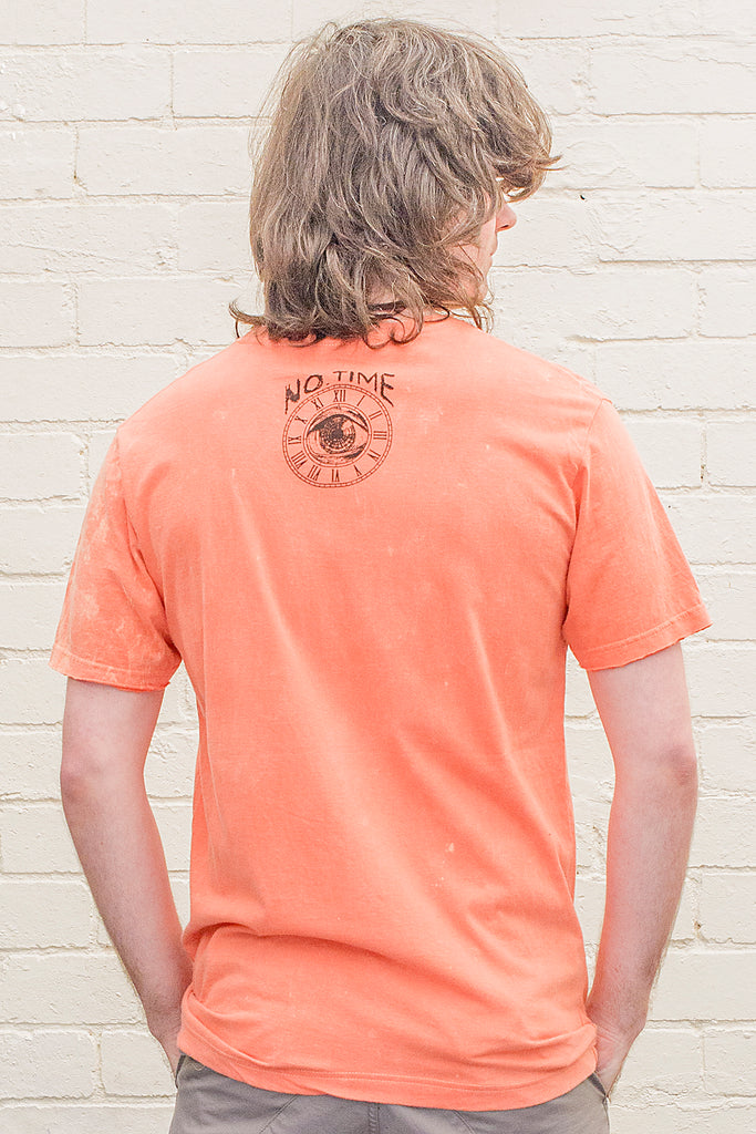 model wearing an orange stonewash t-shirt with the no time brand logo printed on the back