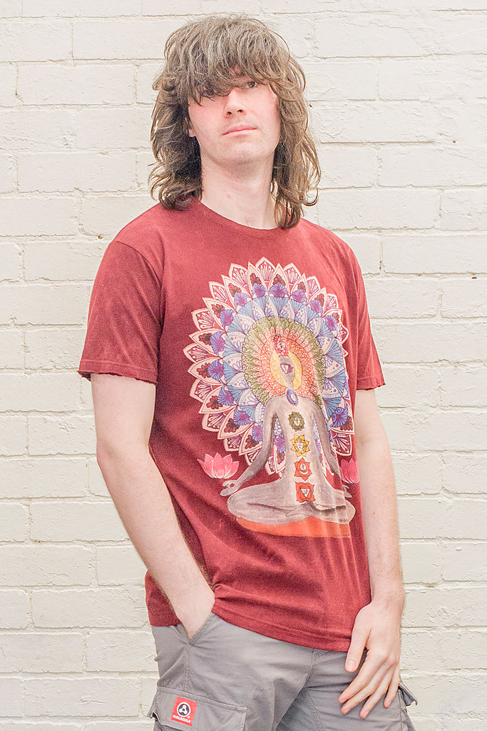 model wearing a dark red or maroon stonewash t-shirt printed with an image of a yoga practitioner in lotus position with the 7 chakras illustrated and with a mandala behind the character viewed from the front