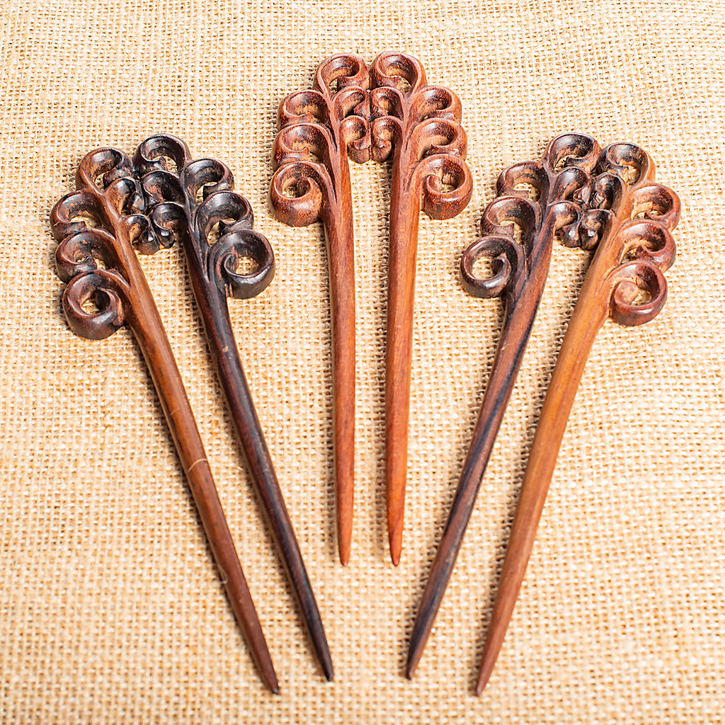 hand made wooden double prong hair stick with naive stylised plant fronds carved at end