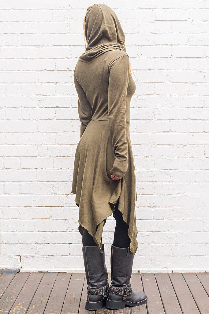 Model wearing a skadi midi length handkerchief hemline knit dress with hoodie and thumbholes in army green from back