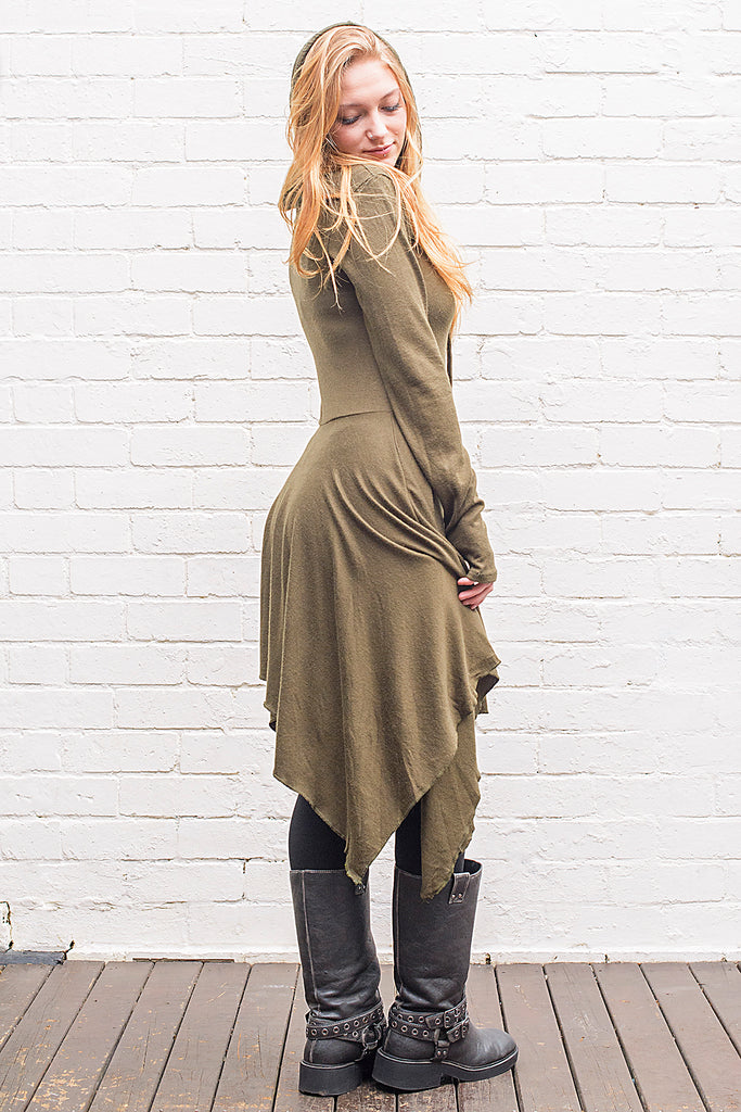 Model wearing a skadi midi length handkerchief hemline knit dress with hoodie and thumbholes in army green from side