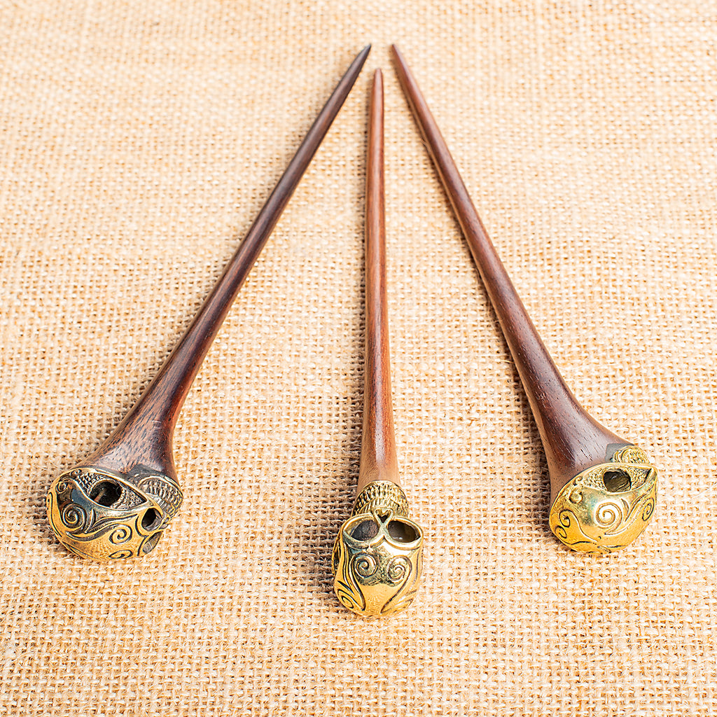 wooden hair stick with ornate carved brass skull at end