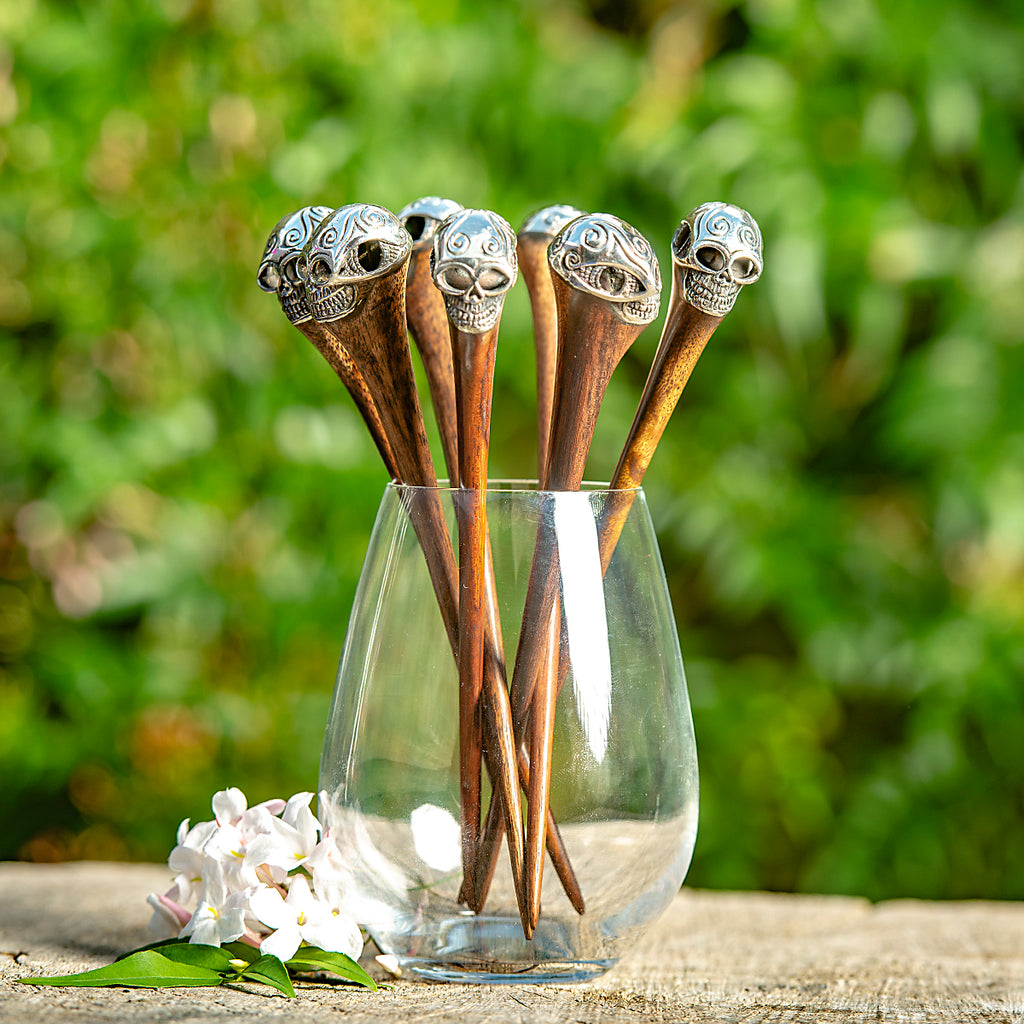 wooden hair stick with intricate carved silver metal skull at end