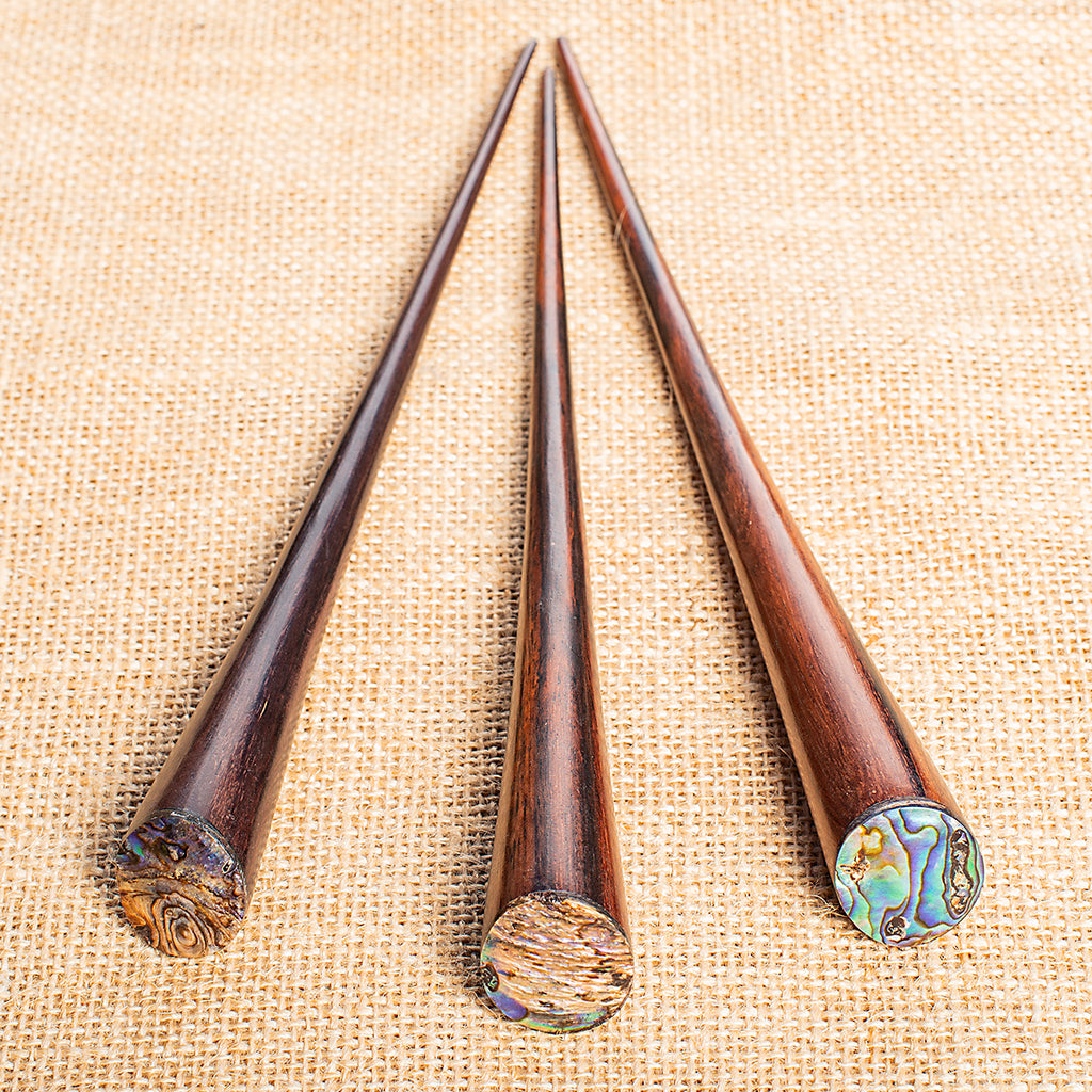 thin cone shaped wooden hair stick with paua mother of pearl inlay on angled end